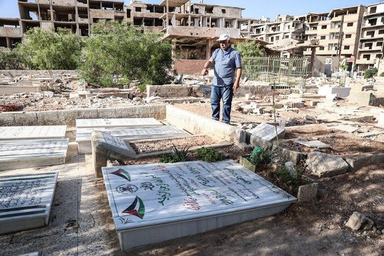 Devrik Esed rejiminin saldırılarında harabeye dönen Yermuk Mezarlığı'nda yakınlarının izini arıyorlar